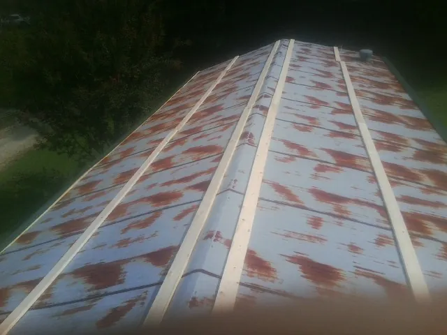 Rusted metal roof panels with new wood purlins before replacement — Storm Damage Roof Repair in Struthers by Roofing Brothers