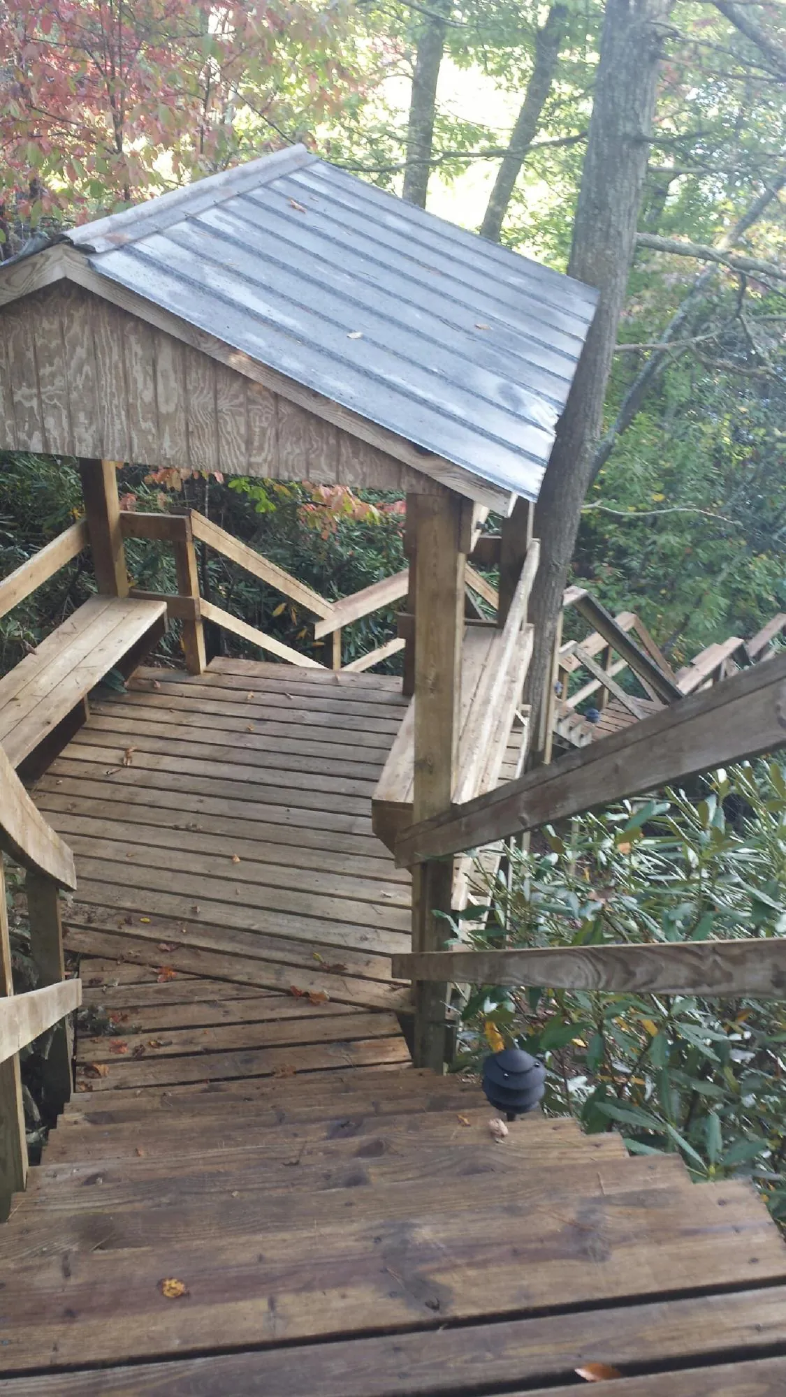 Metal roofed shelter over wooden steps on a wooded walkway — Skylight Repair & Installation work by our crew in Struthers