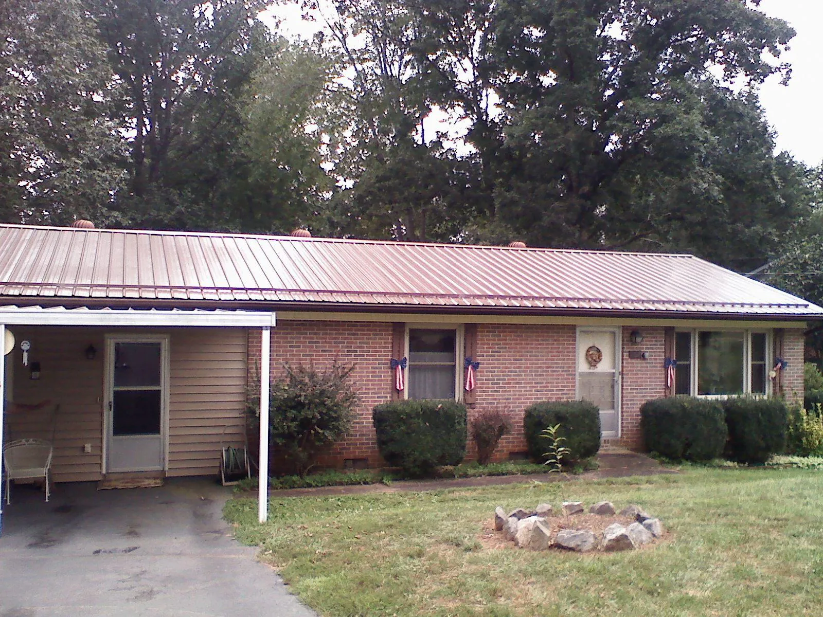 Bronze metal roof and carport on a brick ranch home — Roof Repair work by our crew in Struthers